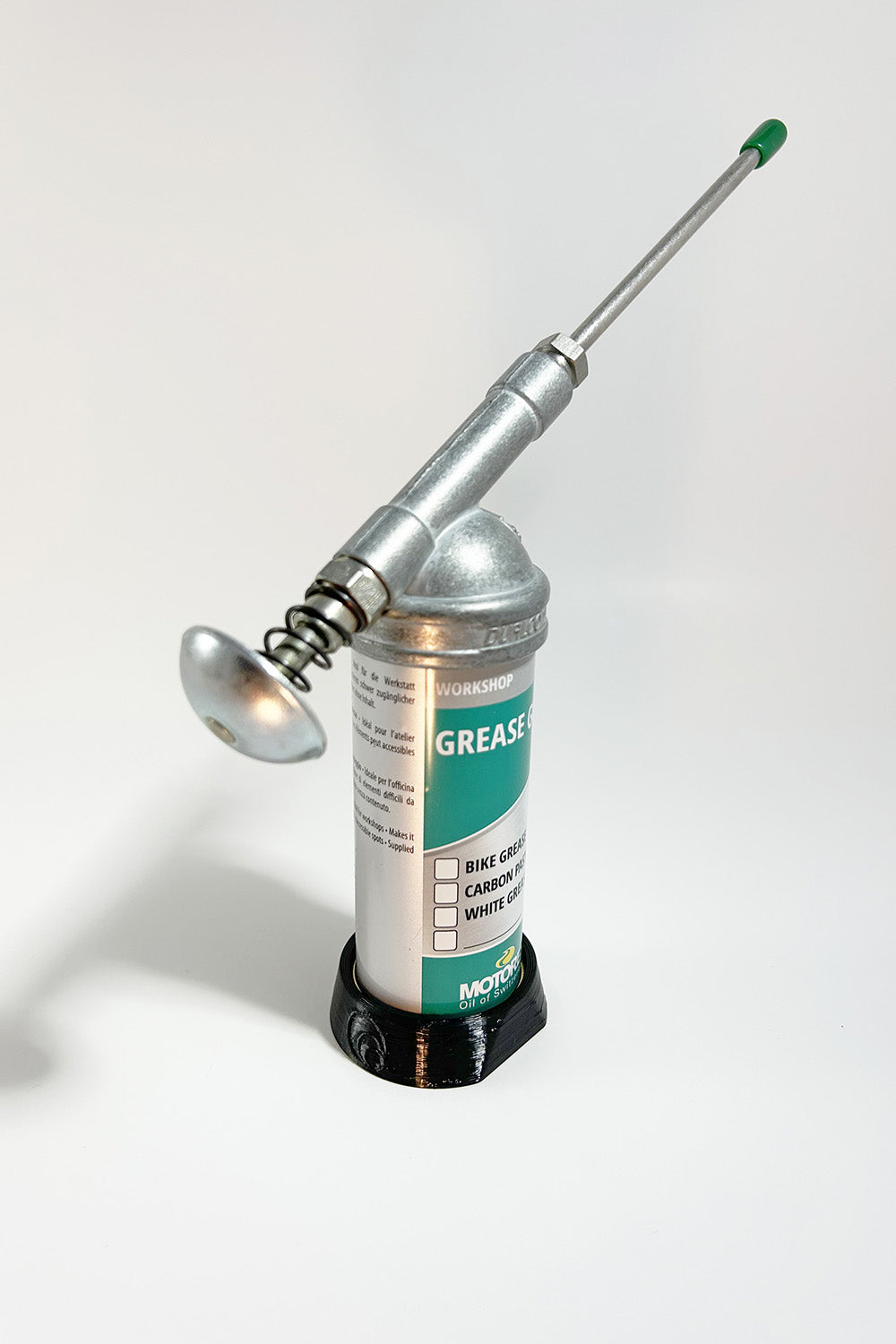 Our 3D printed Grease Gun Stand is a straightforward device that will bring stability to your grease gun, preventing those frustrating spills on your workbench.