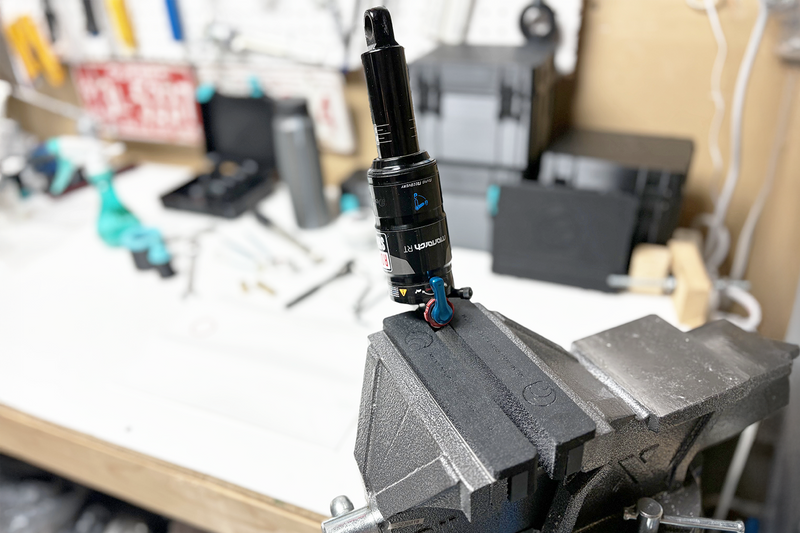 Soft Vise Jaw Pads - PRO mounted in a bench vise, designed to securely hold bike components like suspensions, with a rigid soft-touch material that protects delicate surfaces.